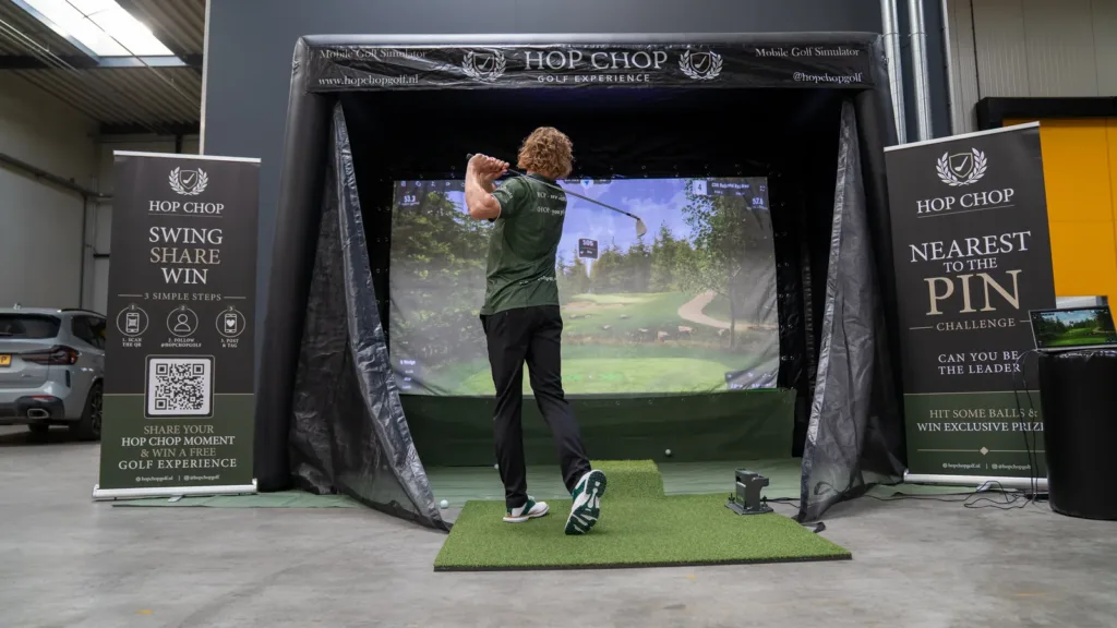 Gast speelt de Nearest to the Pin Challenge op de mobiele golfsimulator van HOP CHOP