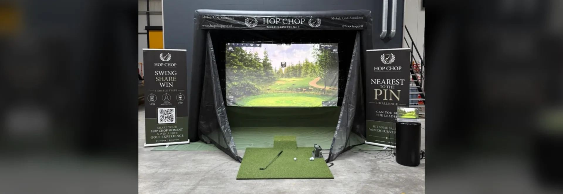 Mobiele golfsimulator van HOP CHOP opgebouwd met afslagmat, scherm en banners