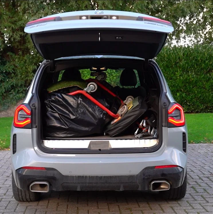 Achterbak van de HOP CHOP auto vol met de mobiele golfsimulator, afslagmat en golfclubs